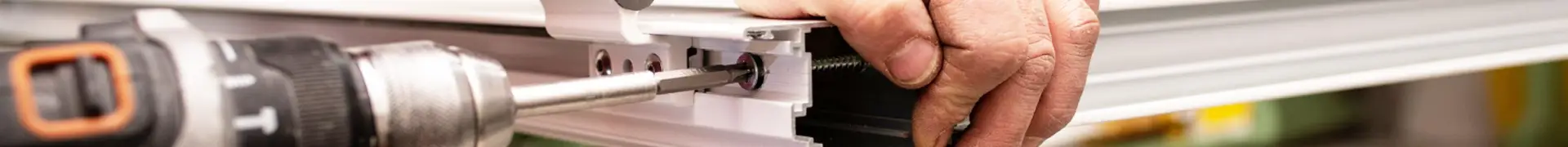Menuisier installant une fenêtre couvert par une assurance décennale